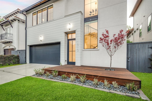view of front of house featuring fence, a front lawn, a garage, stucco siding, and driveway