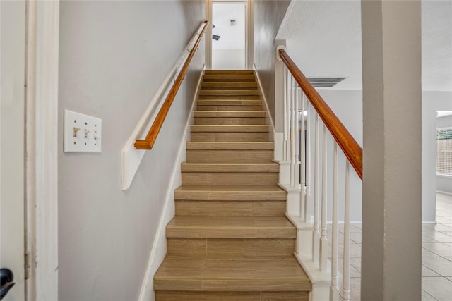 stairway with visible vents and tile patterned flooring