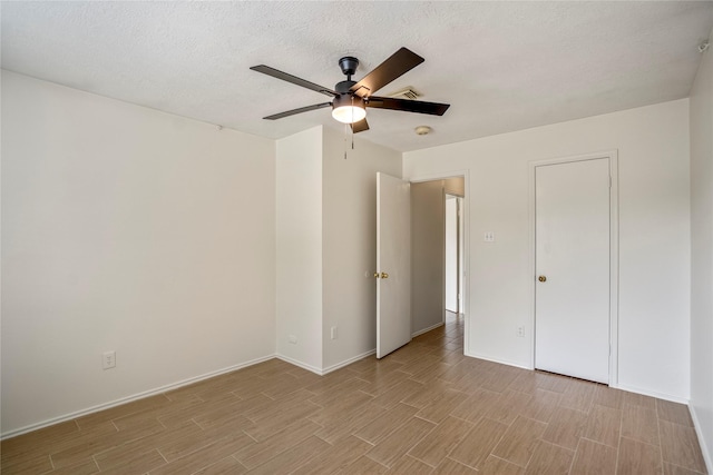 unfurnished bedroom featuring ceiling fan, visible vents, baseboards, and light wood-style floors