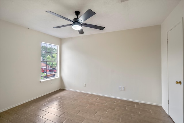 unfurnished room with baseboards, wood tiled floor, and ceiling fan