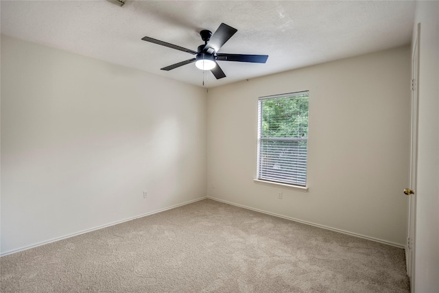 carpeted empty room featuring baseboards and ceiling fan