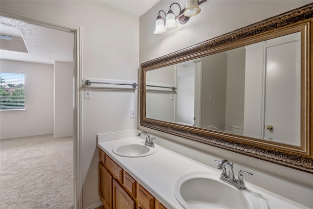 full bath featuring a sink, baseboards, toilet, and double vanity