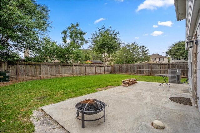 view of yard featuring central air condition unit, a fenced backyard, a patio area, and an outdoor fire pit