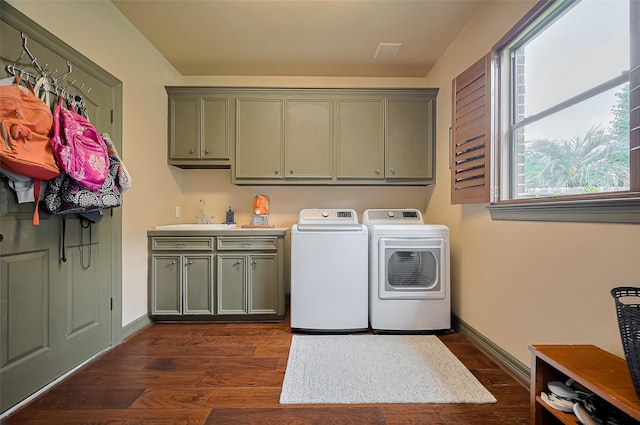 washroom featuring baseboards, dark wood-style floors, washer and clothes dryer, a sink, and cabinet space