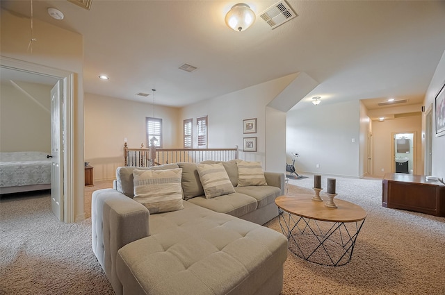 living room featuring baseboards, visible vents, and light carpet