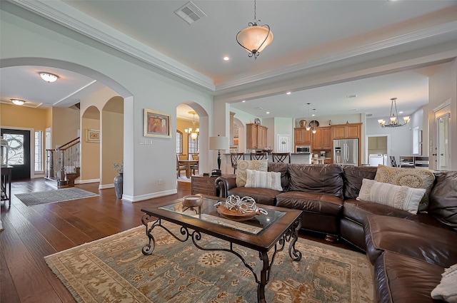 living area featuring arched walkways, a chandelier, baseboards, dark wood-type flooring, and visible vents