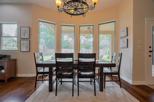 dining space with baseboards, a chandelier, and wood finished floors