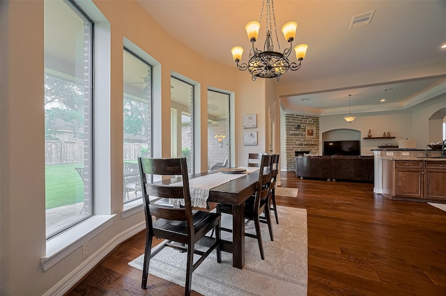 dining room with dark wood-style flooring, a chandelier, visible vents, and a wealth of natural light