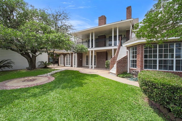 803 Mahogany Run Dr, Katy, TX 77494 - rear view of house featuring french doors, a chimney, a lawn, brick siding, and a balcony
