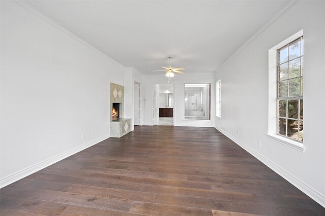 803 Mahogany Run Dr, Katy, TX 77494 - unfurnished living room featuring ornamental molding, a ceiling fan, dark wood finished floors, baseboards, and a fireplace