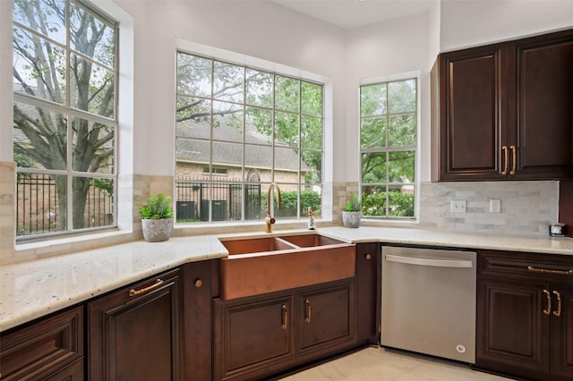 803 Mahogany Run Dr, Katy, TX 77494 - kitchen featuring stainless steel dishwasher, a sink, backsplash, light stone countertops, and dark brown cabinetry