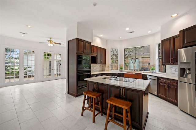 803 Mahogany Run Dr, Katy, TX 77494 - kitchen with black appliances, tasteful backsplash, a kitchen island, recessed lighting, and a ceiling fan
