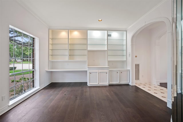 803 Mahogany Run Dr, Katy, TX 77494 - unfurnished dining area with arched walkways, dark wood-style floors, crown molding, baseboards, and built in shelves