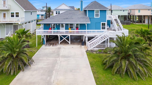 13114 Coronado Dr, Freeport, TX 77541 - view of front facade with driveway, a residential view, a carport, stairway, and a shingled roof