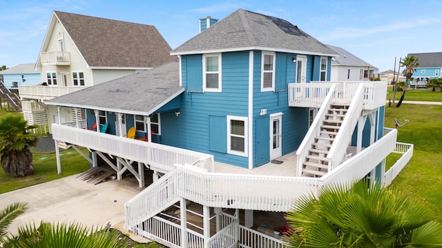 13114 Coronado Dr, Freeport, TX 77541 - back of house featuring stairway, a deck, a shingled roof, and a lawn