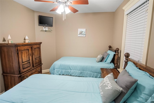 bedroom featuring baseboards and ceiling fan