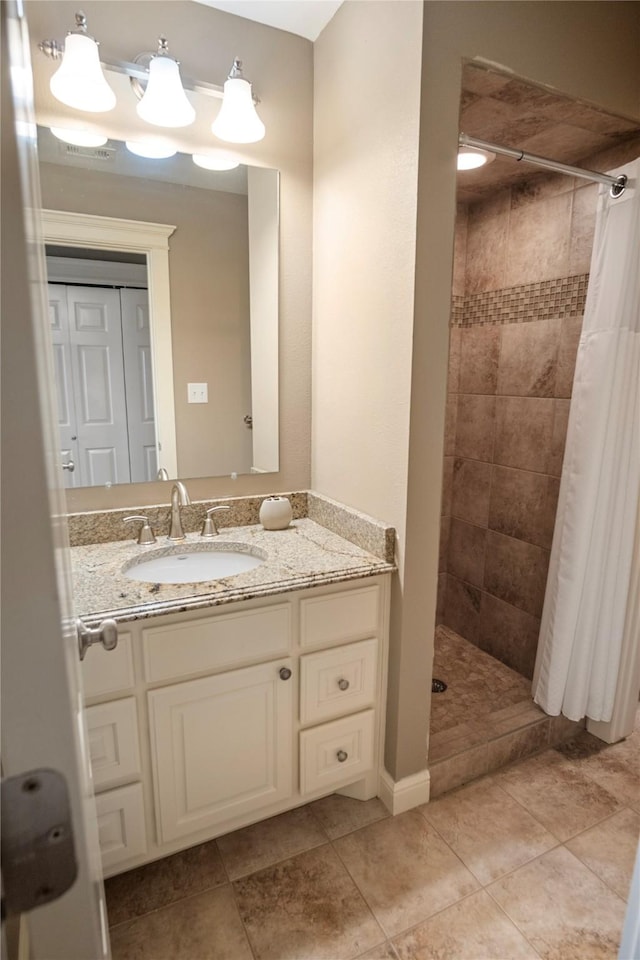 full bathroom with vanity, tile patterned flooring, and tiled shower