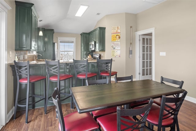 dining area featuring baseboards, dark wood-style floors, and lofted ceiling