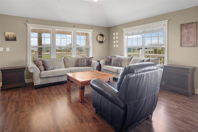 living area featuring plenty of natural light, dark wood-style floors, and lofted ceiling