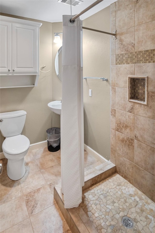bathroom featuring baseboards, a stall shower, toilet, and visible vents