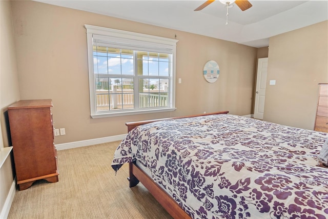 carpeted bedroom featuring baseboards and a ceiling fan