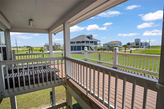 wooden deck featuring a yard, a residential view, and a porch