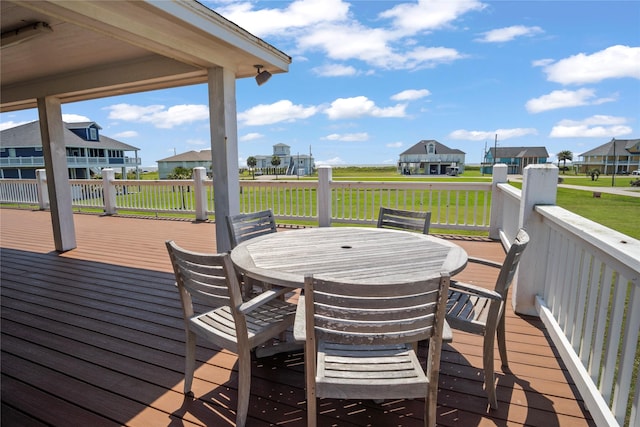 wooden deck featuring a residential view, outdoor dining space, and a yard