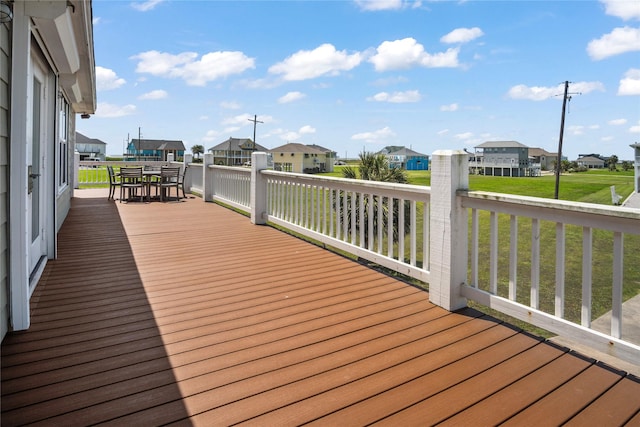 wooden deck featuring a lawn, a residential view, and outdoor dining space