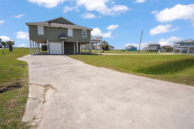 coastal home with a residential view, an attached garage, concrete driveway, and a front lawn