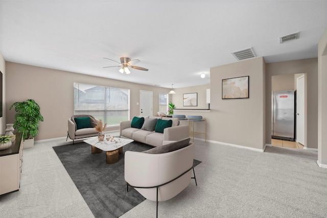 carpeted living room featuring baseboards, ceiling fan, and visible vents