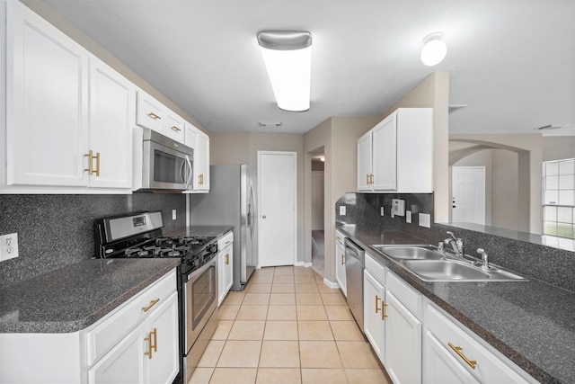 kitchen featuring white cabinetry, appliances with stainless steel finishes, a sink, and tasteful backsplash