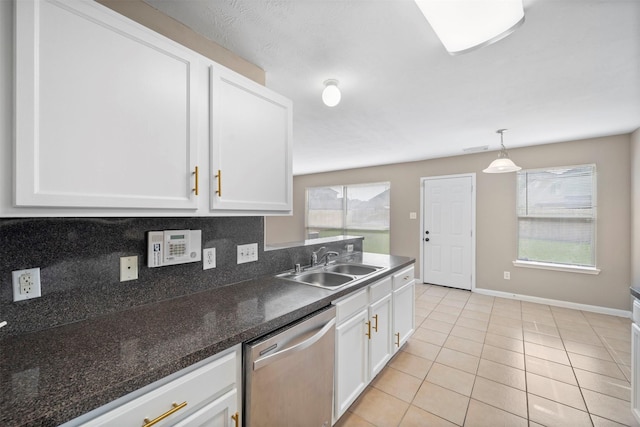 kitchen featuring stainless steel dishwasher, a sink, white cabinetry, and plenty of natural light