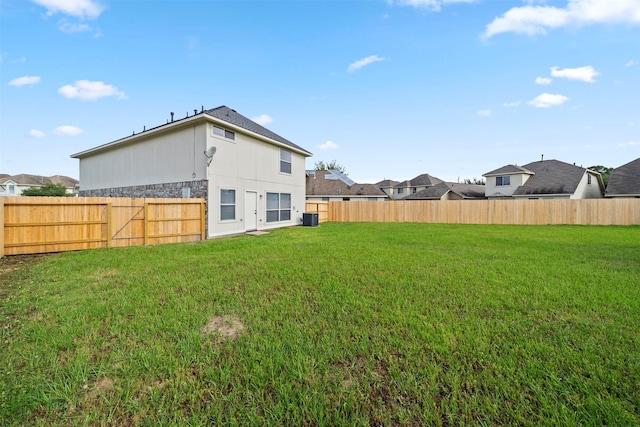 view of yard with central AC and a fenced backyard