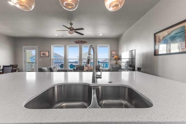 room details featuring a sink, ceiling fan, light stone countertops, and recessed lighting