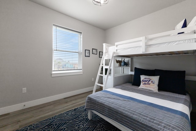bedroom with baseboards and wood finished floors