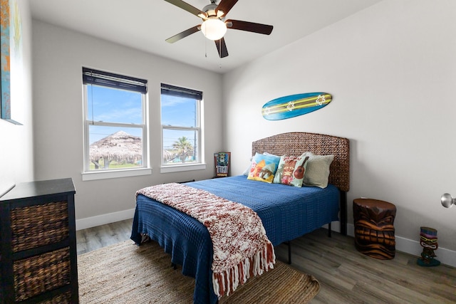 bedroom with baseboards, ceiling fan, and wood finished floors