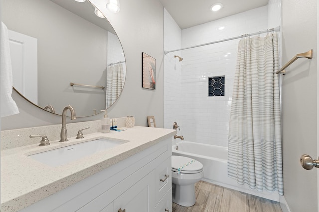 full bathroom with vanity, wood finished floors, toilet, recessed lighting, and shower / bath combo