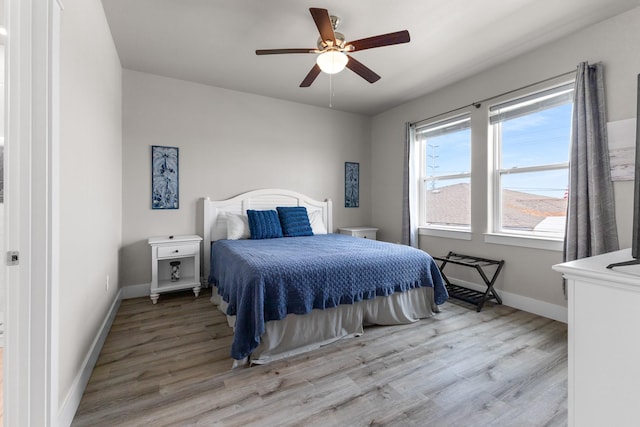 bedroom featuring baseboards, a ceiling fan, and light wood finished floors