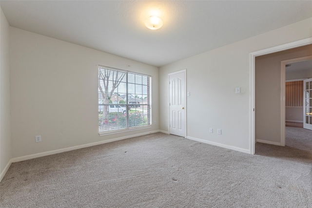 empty room featuring carpet floors and baseboards