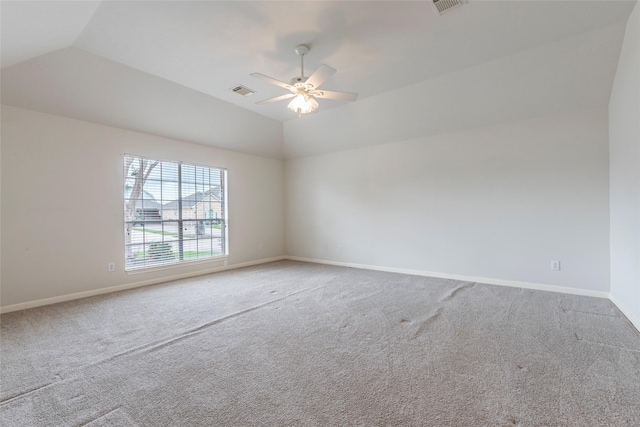 carpeted spare room featuring baseboards, a ceiling fan, vaulted ceiling, and visible vents