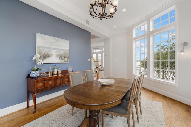 dining room featuring an inviting chandelier, ornamental molding, visible vents, baseboards, and light wood-type flooring