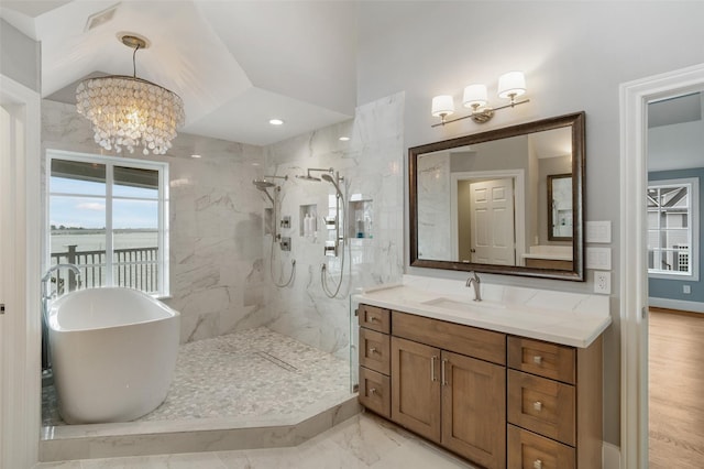 bathroom featuring baseboards, vanity, a chandelier, a marble finish shower, and a soaking tub