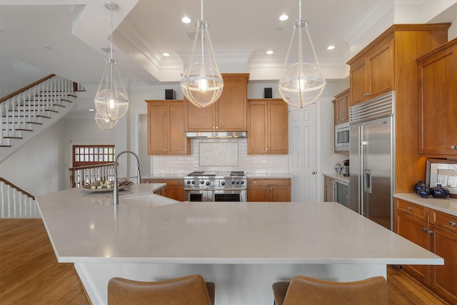 kitchen with built in appliances, crown molding, a sink, and wood finished floors