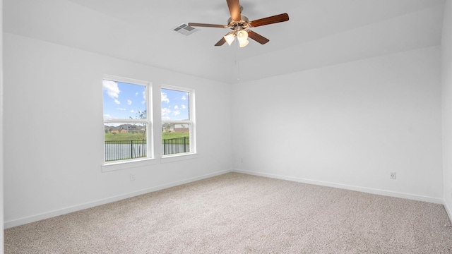 empty room featuring carpet flooring, ceiling fan, visible vents, and baseboards