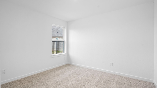 unfurnished room featuring light colored carpet and baseboards