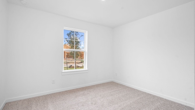 carpeted spare room featuring baseboards and a wealth of natural light