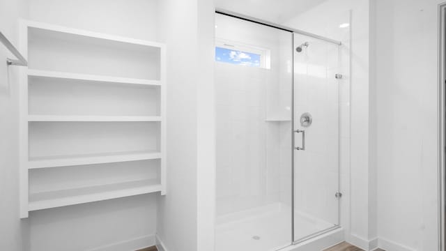full bath featuring baseboards and a shower stall