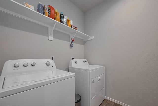 washroom featuring baseboards, dark wood-style flooring, laundry area, and washer and clothes dryer