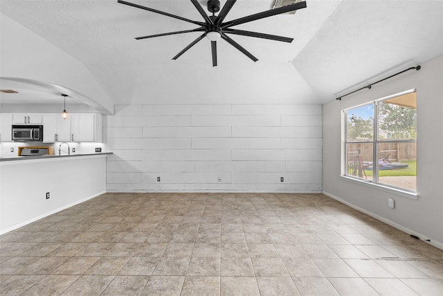 unfurnished living room featuring arched walkways, a ceiling fan, and lofted ceiling