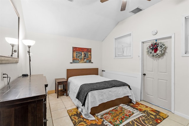 bedroom featuring ceiling fan, visible vents, light tile patterned floors, baseboards, and lofted ceiling